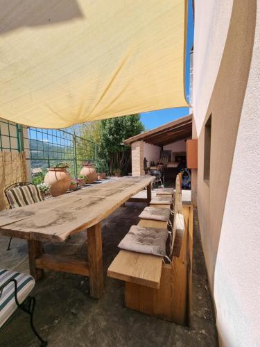 a long wooden table and chairs on a patio at Podere Vecci in Dicomano