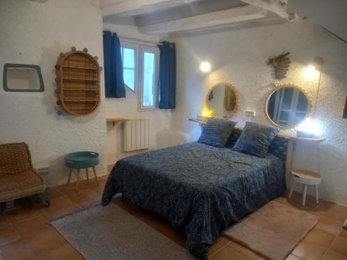 ein Schlafzimmer mit einem Bett und zwei Spiegeln an der Wand in der Unterkunft Maison médiévale avec jardin dans charmant village in Vers