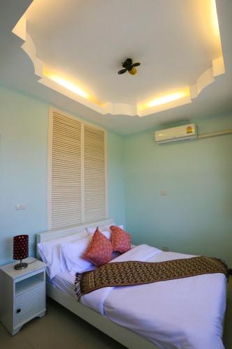 - une chambre avec un lit et un ventilateur de plafond dans l'établissement พลาบุรี รีสอร์ท, à Ban Phala