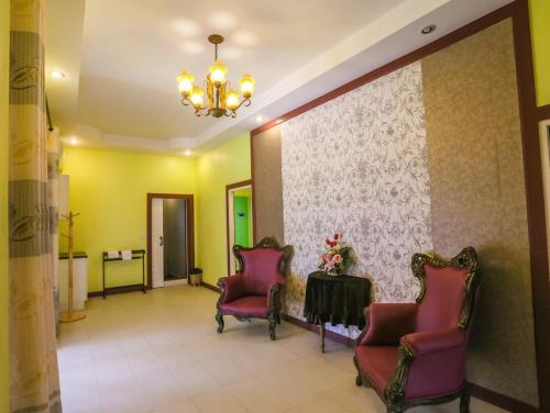 - une salle d'attente avec deux chaises et une table dans l'établissement พลาบุรี รีสอร์ท, à Ban Phala