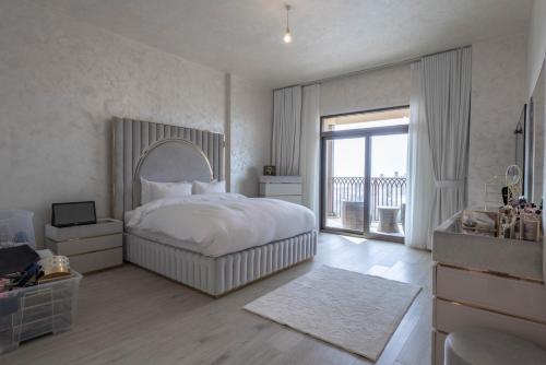 um quarto branco com uma cama e uma varanda em Luxury Room Burj al Arab FRONT em Dubai