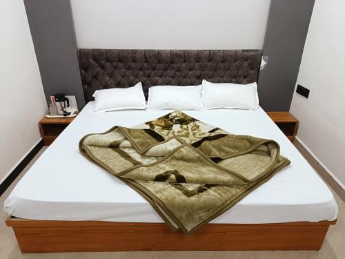 un letto con una coperta sopra di Hotel Shreem a Ujjain