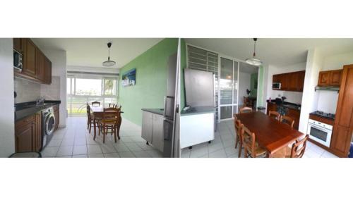 a kitchen and dining room with a table and a refrigerator at Appartement en résidence avec piscine in Le Gosier