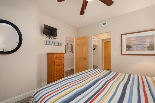 a bedroom with a bed and a dresser and a mirror at FF215 First Flight Retreat 215 in Kill Devil Hills