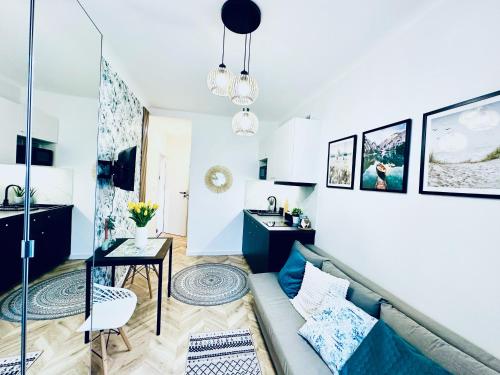 a living room with a couch and a table at Olivia Apartments - Słoneczny apartament w centrum Warszawy, Plac Unii Lubelskiej, Łazienki Królewskie, Pole Mokotowskie - 24h check-in in Warsaw