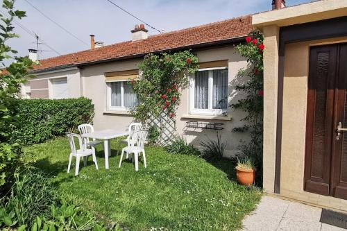 - une table et des chaises dans la cour d'une maison dans l'établissement Plain pied calme parking privé 5 lits 1 lit bébé proximité Metz, à Woippy