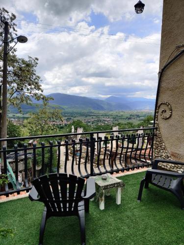 a balcony with two chairs and a bench on the grass at B&B LE GRETTE in Gioia dei Marsi