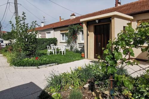 une maison avec une table et des chaises dans la cour dans l'établissement Plain pied calme parking privé 5 lits 1 lit bébé proximité Metz, à Woippy
