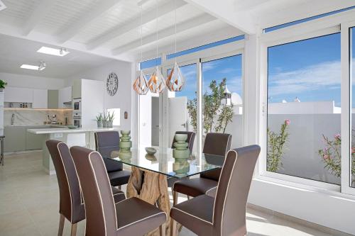 a dining room with a glass table and chairs at Field of Dreams in Playa Blanca