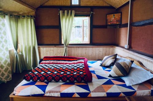 a bedroom with a bed in a room with a window at Wake In Himalayas in Pelling