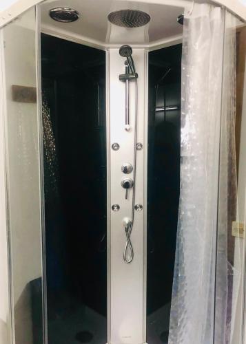 La salle de bains est pourvue d'une douche avec rideau de douche. dans l'établissement La Cabane, à Mazamet