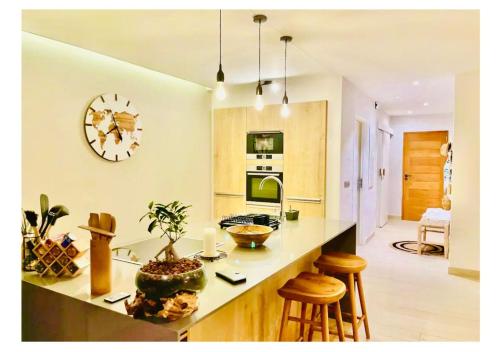 a kitchen with a counter and a clock on the wall at Escapade romantique Baie Nettlé in Baie Nettle