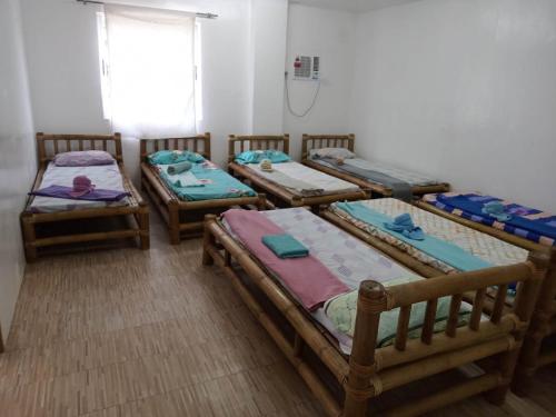 3 camas de madera en una habitación con ventana en Diniwid Garden Beach, en Boracay