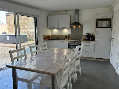 a kitchen with a wooden table and white cabinets at 302 - Bel appartement rénové en centre de FREHEL in Frehel