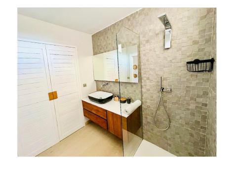 a bathroom with a shower and a sink and a shower at Escapade romantique Baie Nettlé in Baie Nettle