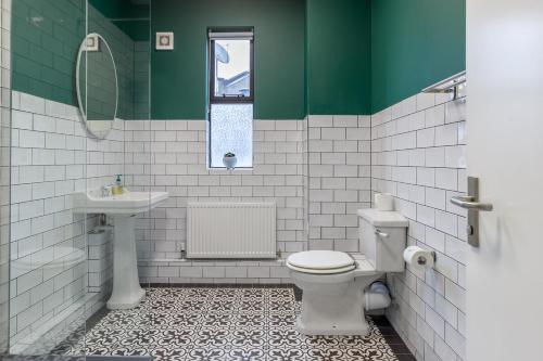 a green and white bathroom with a toilet and sink at Dublin Castle Suites in Dublin