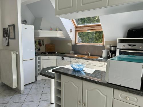 a kitchen with white cabinets and a window at 314 - Maison 4p à moins d'un km de l'Anse du Croc in Frehel