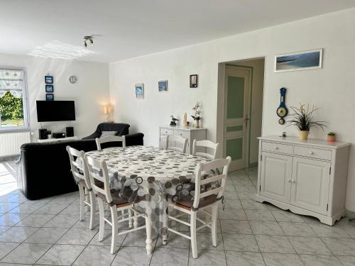 a living room with a dining room table and chairs at 314 - Maison 4p à moins d'un km de l'Anse du Croc in Frehel