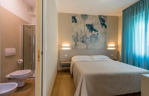 pokój hotelowy z łóżkiem i toaletą w obiekcie Residence Stella w mieście Marina di Massa