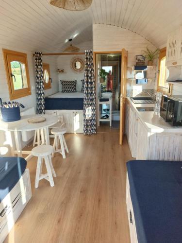 - une cuisine et un coin repas dans une petite maison dans l'établissement Le Domaine des Nomades, à Mimeure