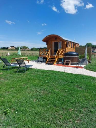 une cabane avec un barbecue et une table de pique-nique dans un champ dans l'établissement Le Domaine des Nomades, à Mimeure