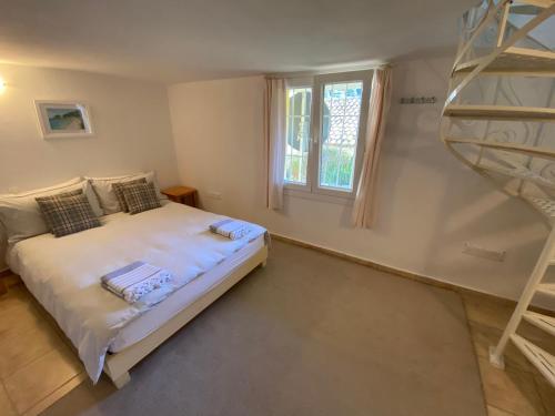 a bedroom with a bed and a spiral staircase at Villa Jasmine, Sea and Mountain View in peaceful hamlet in Kriniás