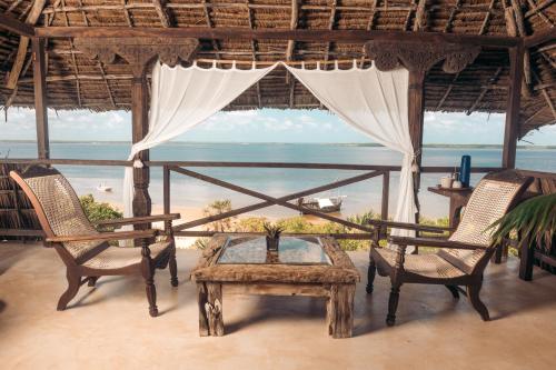 a room with a table and two chairs and a view of the ocean at The Cabanas Lamu in Lamu