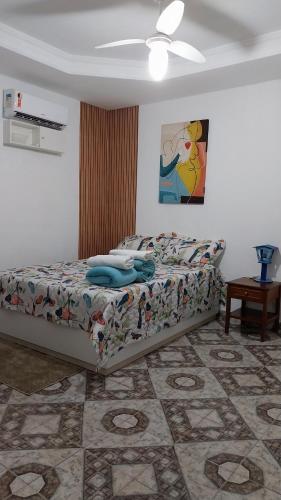 een slaapkamer met een bed en een plafondventilator bij Casa ampla com Wi-Fi e garagem para dois veículos in Campos dos Goytacazes