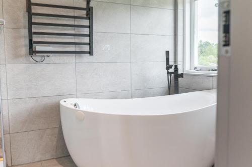 a white bath tub in a bathroom with a window at The Log House in Ambleside