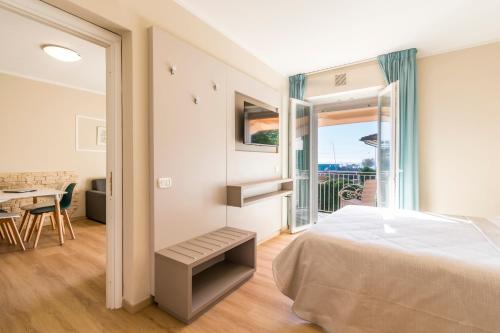 a bedroom with a bed and a table and a balcony at Residence Stella in Marina di Massa