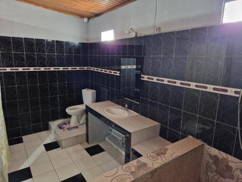 une salle de bain avec toilettes et lavabo dans l'établissement Bungalow chez Mouch Nosy-Be 2, à Nosy Be