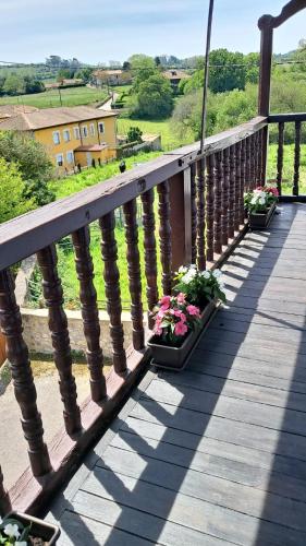 three potted plants on a wooden balcony with a view at Hotel BESTPRICE Santillana in Santillana del Mar