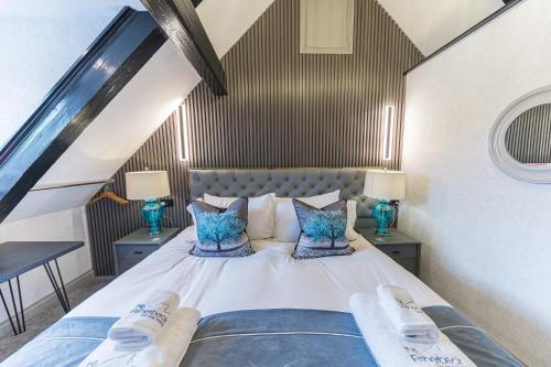 a bedroom with a large bed with blue pillows at The Log House in Ambleside