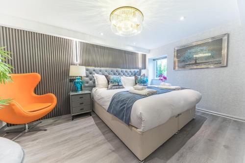 a bedroom with a large bed and an orange chair at The Log House in Ambleside