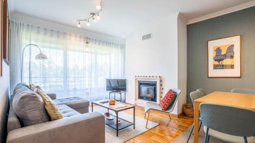 a living room with a couch and a fireplace at Infante Cozy 1BR w Parking by LovelyStay in Vila Nova de Gaia