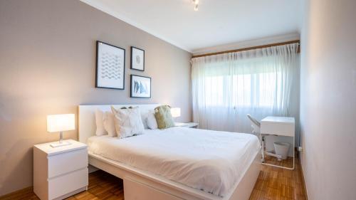 a white bedroom with a bed and a desk at Infante Cozy 1BR w Parking by LovelyStay in Vila Nova de Gaia