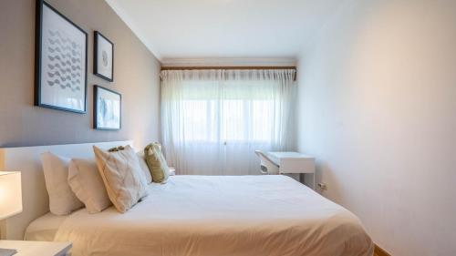 a bedroom with a white bed and a window at Infante Cozy 1BR w Parking by LovelyStay in Vila Nova de Gaia