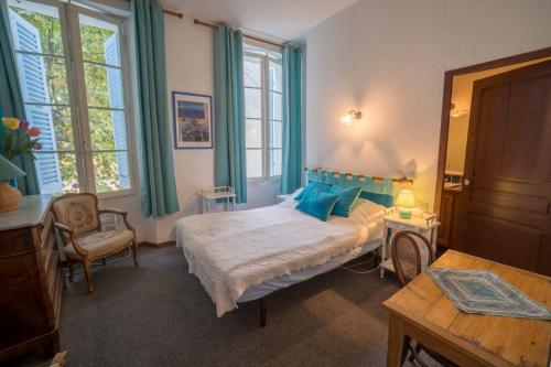 une chambre avec un lit avec des oreillers bleus dans l'établissement Wangberg Provence, à Villecroze