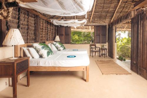 1 dormitorio con 1 cama y 1 mesa en una habitación en The Cabanas Lamu, en Lamu