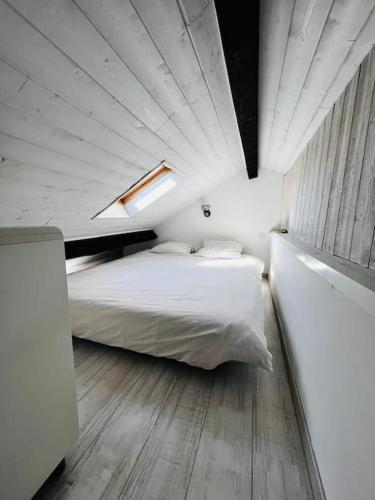 une chambre avec un lit blanc et une fenêtre dans l'établissement Appartement cosy à CAPBRETON, la plage à pied, à Capbreton