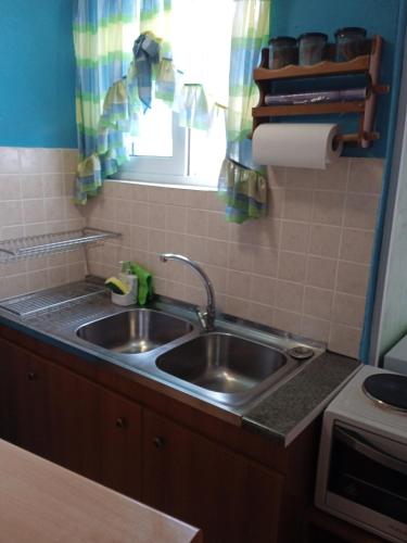 a kitchen with a stainless steel sink and a window at PRIVATE SEASIDE GUEST HOUSE... in Agia Marina Mikrolimanou