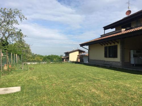 a large yard next to a house with a building at Casa Gatti: villa con giardino con accesso indipendente in Rivanazzano