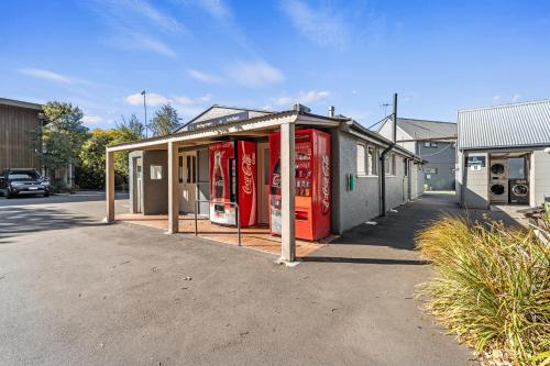 a building with two coca cola machines in a parking lot at Tasman Holiday Parks - Christchurch in Christchurch