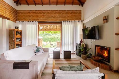 - un salon avec un canapé blanc et une cheminée dans l'établissement Casa de campo Secretário/ Pedro do Rio RJ, à Petrópolis
