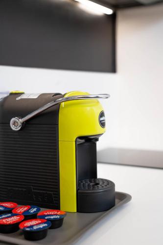 a yellow toaster sitting on a table with remote controls at CityU Grazioli 27 Appartamento Trento Città - 2 stanze con 2 parcheggi privati gratuiti in Trento