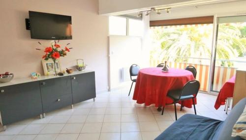 une salle à manger avec une table et des chaises rouges dans l'établissement Résidence l'Orée du Golf Mandelieu La Napoule, à Mandelieu-la-Napoule