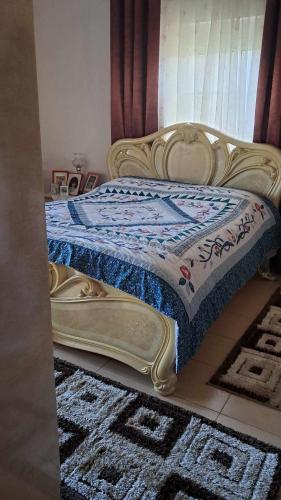 Una cama con edredón en una habitación en Nevi House en Berat