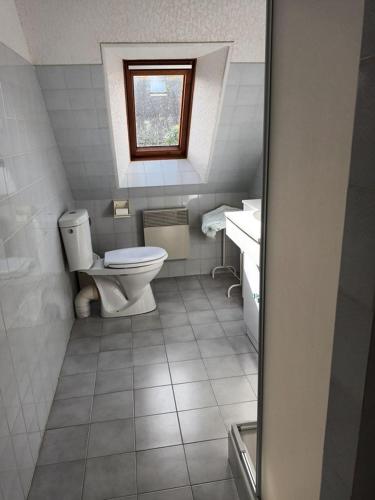 une salle de bain avec toilettes, lavabo et fenêtre dans l'établissement villa les pieds dans l'eau, à Plouhinec