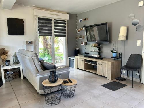 un salon avec un canapé et une télévision à écran plat dans l'établissement 952 - Belle Maison 6 couchages dans le charmant village de La Bouillie, à La Bouillie