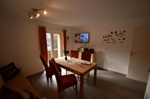 a dining room with a wooden table and chairs at Ferienwohnung Chow Chow in Nauders